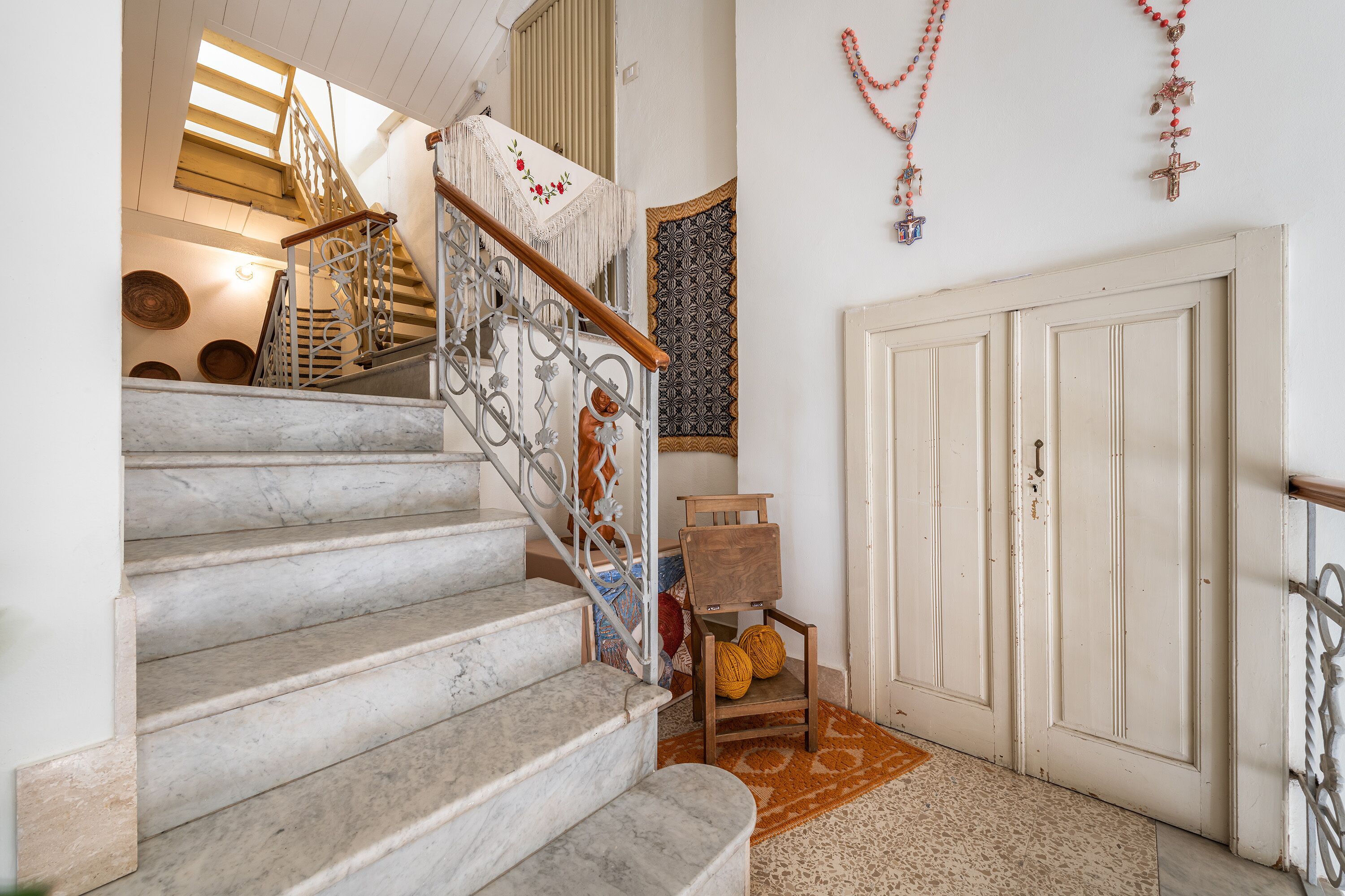 Un escalier avec une rampe en bois et une décoration murale à motifs.