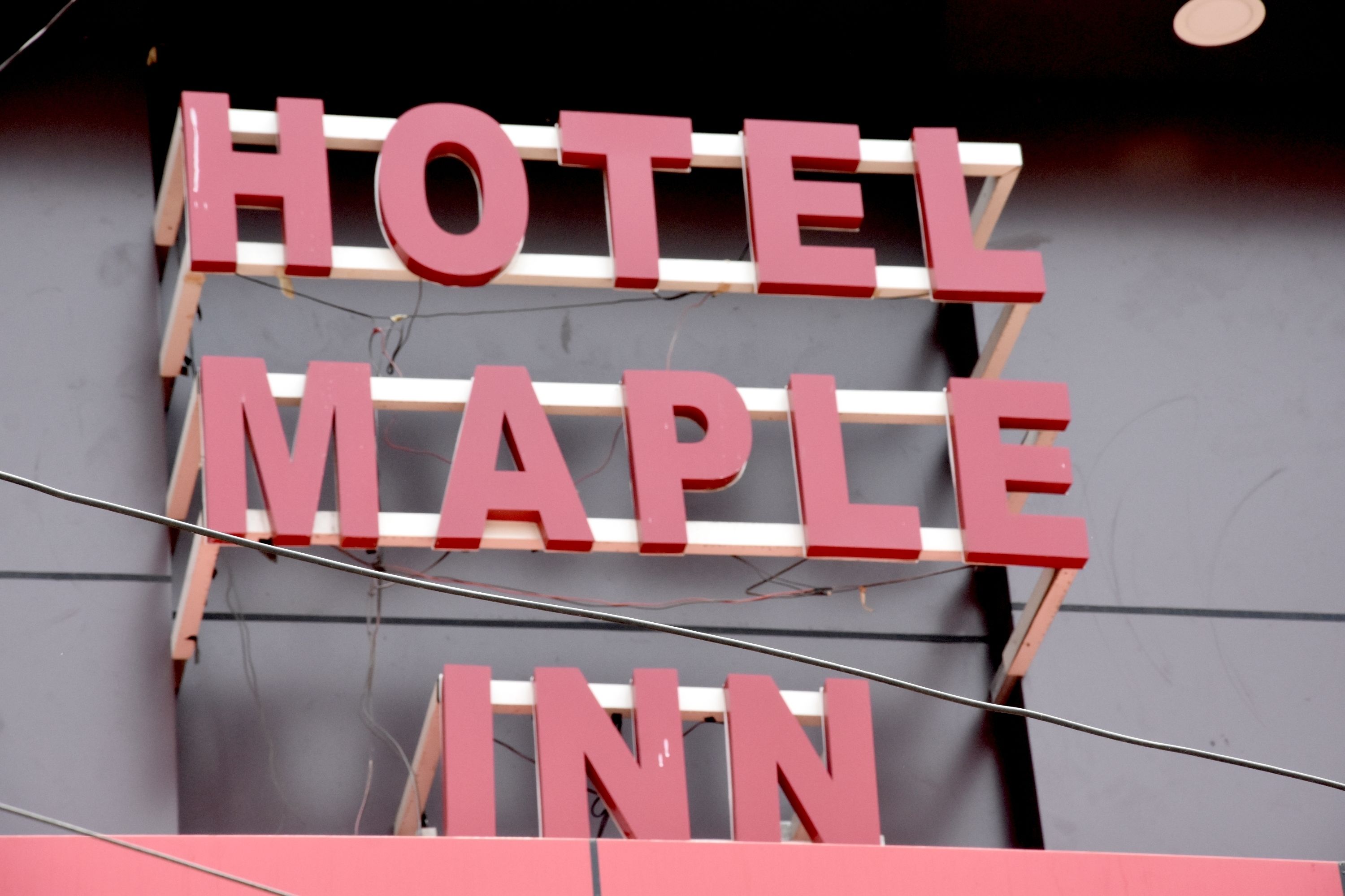 A sign with the words "HOTEL MAPLE INN" in large, bold letters.