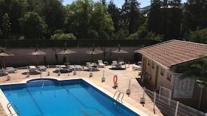 A rectangular swimming pool with a starfish decoration, surrounded by lounge chairs and umbrellas. - Hostal Restaurante Cuatro Caminos (Piedrabuena)