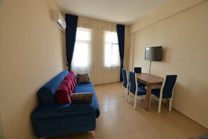 Suite familiar, varias camas | Sala de estar | Televisión LED de 32 pulgadas con canales por satélite, una televisión