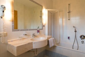 Un baño con lavamanos, espejo y ducha.