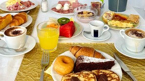 Un buffet de petit-déjeuner proposant une variété d'aliments, de boissons et d'ustensiles.