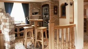 Un interior acogedor con chimenea de piedra, taburetes de madera y piso de baldosas.