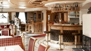 Un restaurante con zona de bar, muebles de madera y chimenea.