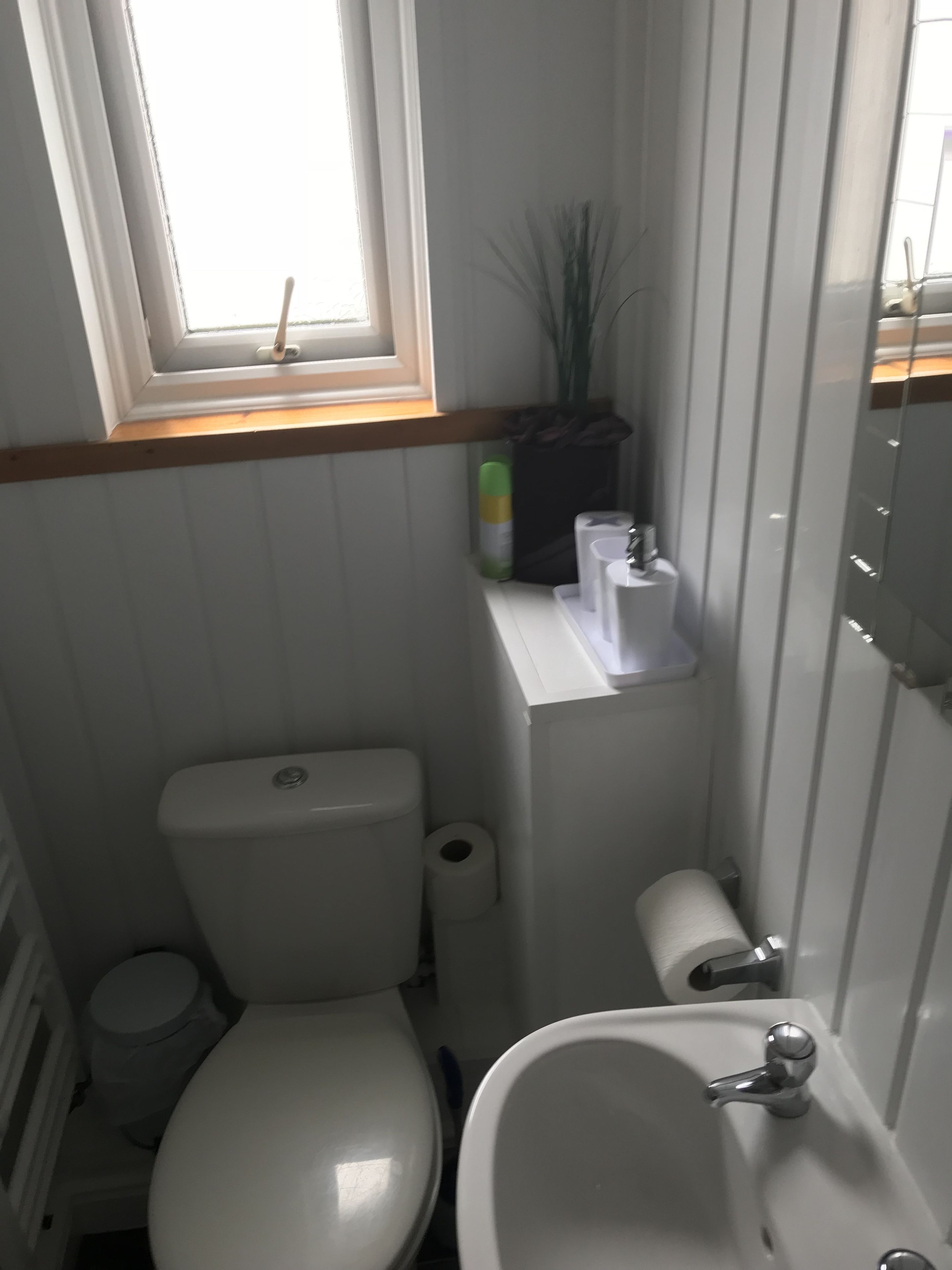 A compact bathroom with a toilet, bidet, and sink.