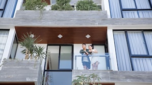 A modern building with a balcony, wooden beams, and potted plants. - Animor Green Home Da Nang (Da Nang)