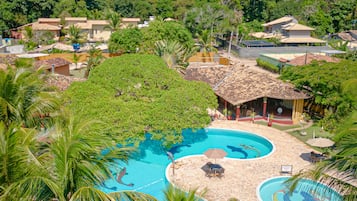 Una piscina al aire libre, sombrillas, sillones reclinables de piscina