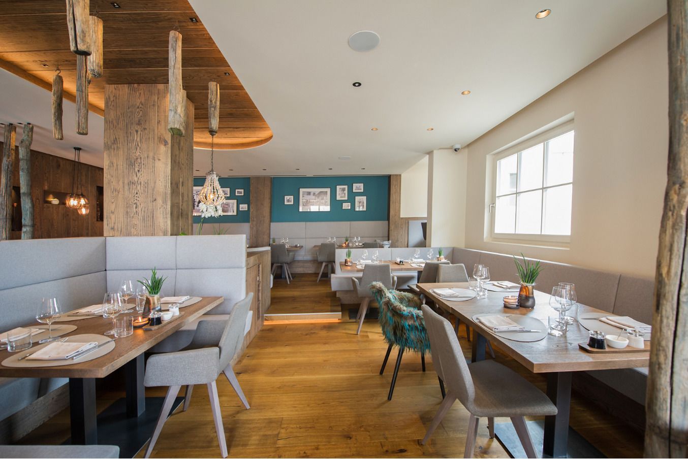 A modern restaurant with wooden accents, booths, and a view of the city.