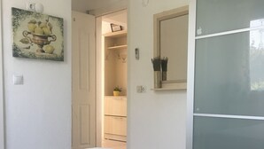 Ein Schlafzimmer mit einem großen Bett, einem Kleiderschrank, einem Spiegel und einer Tür zum Badezimmer.