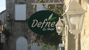 Ein Steinhaus mit einem Schild für 'Defne Ev Hotel'.