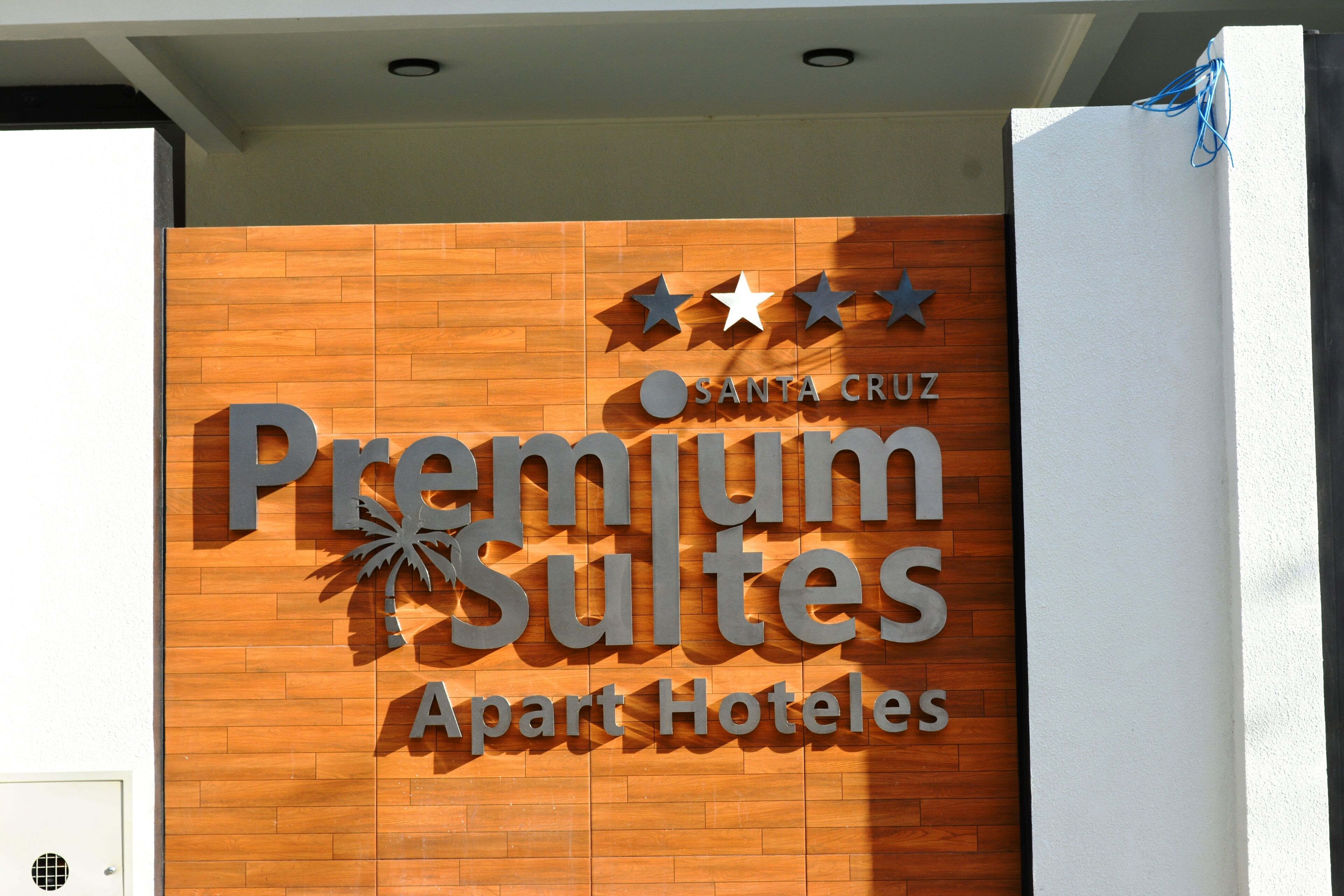 A sign for "Premium Suites Apart Hotels" with a wooden facade and three stars above the name.