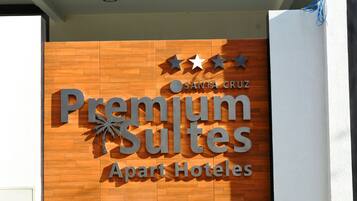A sign for "Premium Suites Apart Hotels" with a wooden facade and three stars above the name.