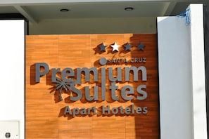 Un letrero para "Premium Suites Apart Hotels" con fachada de madera y tres estrellas sobre el nombre.