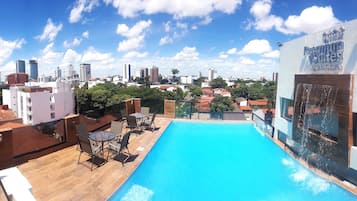 Una piscina al aire libre, sillones reclinables de piscina