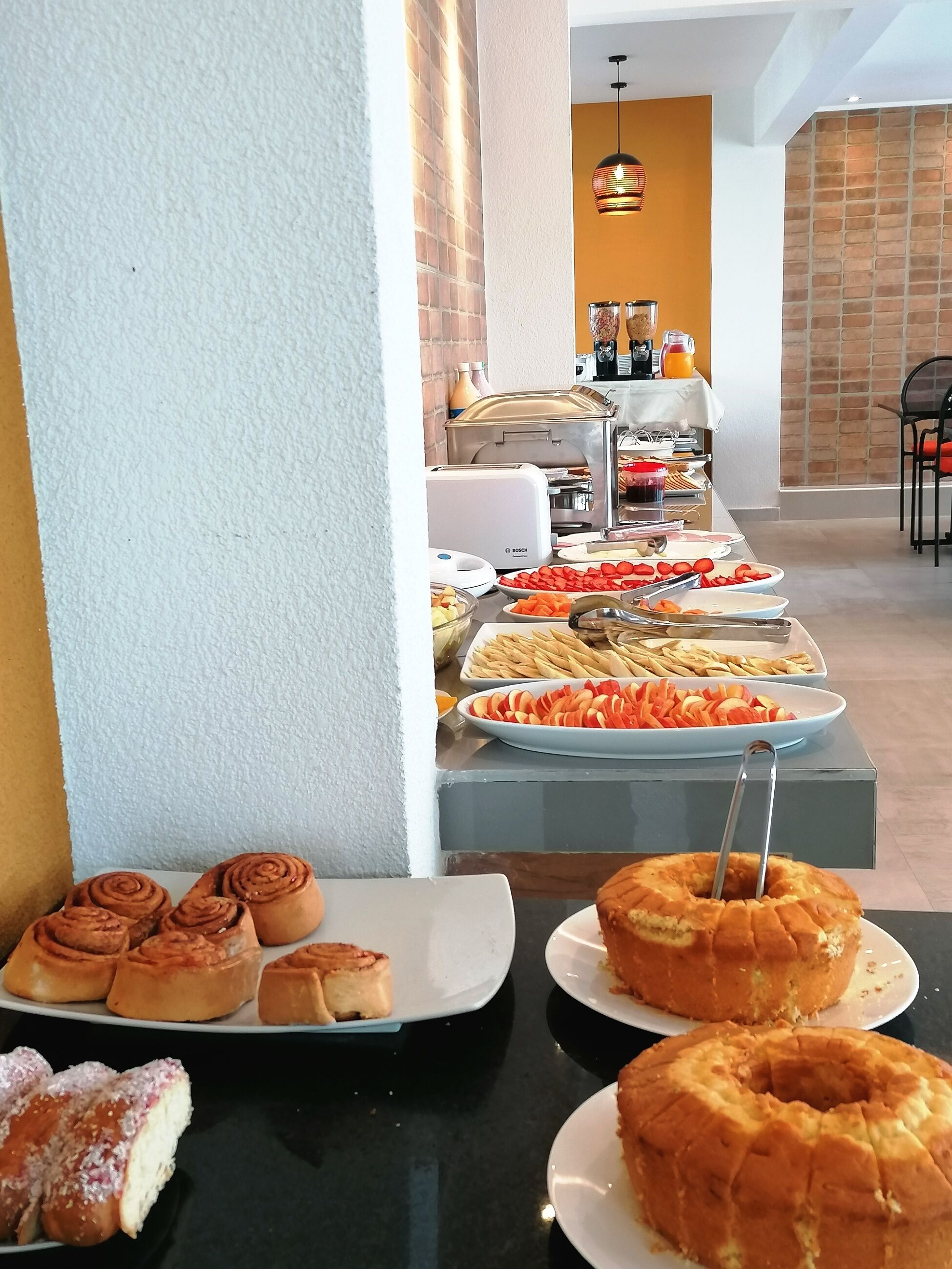 A buffet with various food items including pastries and fruits.