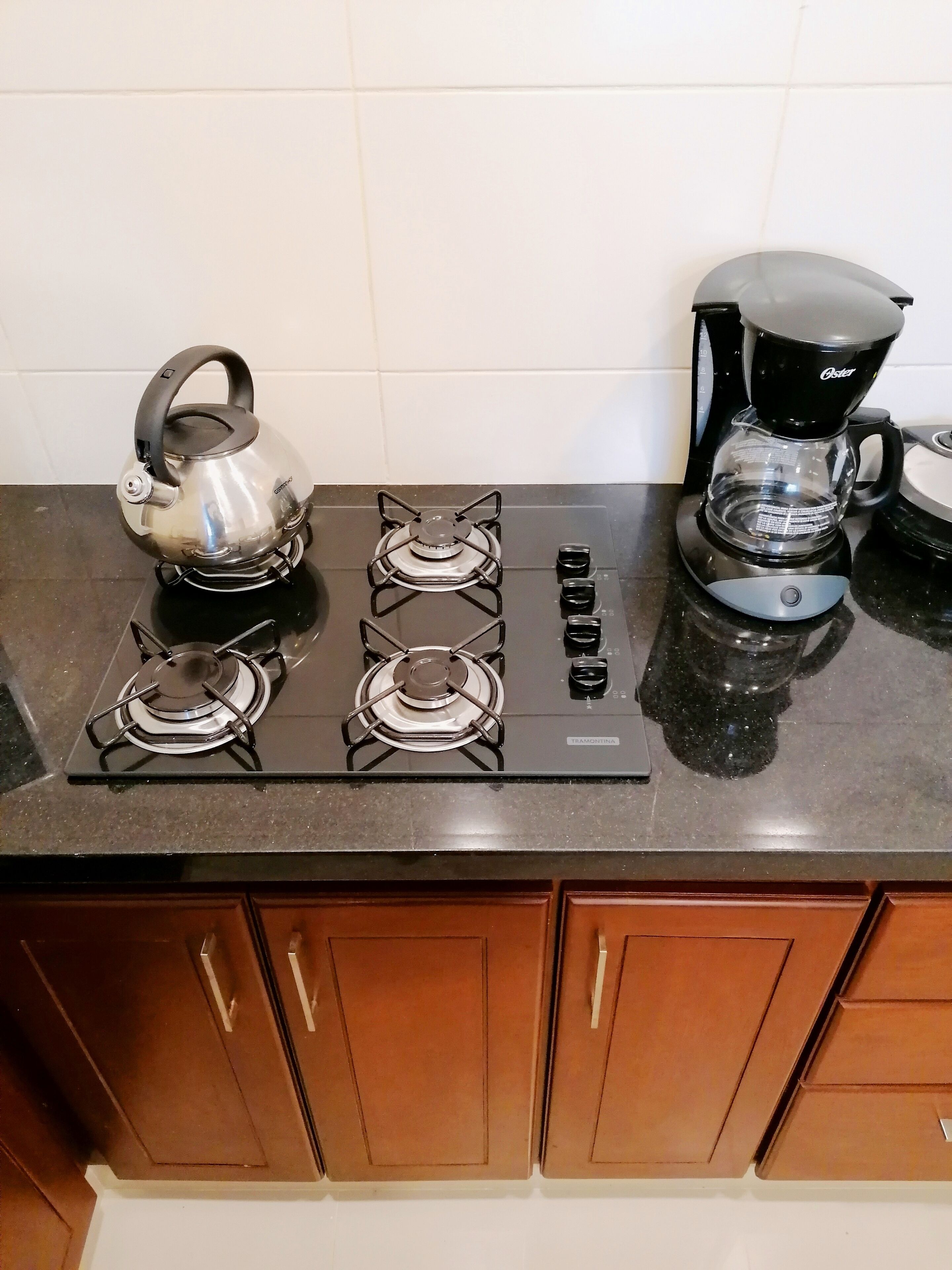 Una cucina con piano cottura a gas, bollitore e macchina per il caffè.