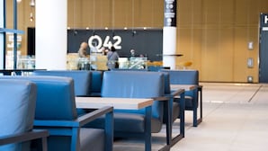 Un intérieur moderne avec des sièges bleus et un panneau bien visible portant l’inscription « Q42 » à l’arrière-plan.