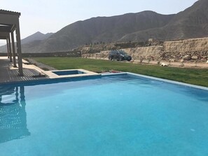 A swimming pool with a view of mountains in the background. - MCV Holiday Home (Pachacámac)