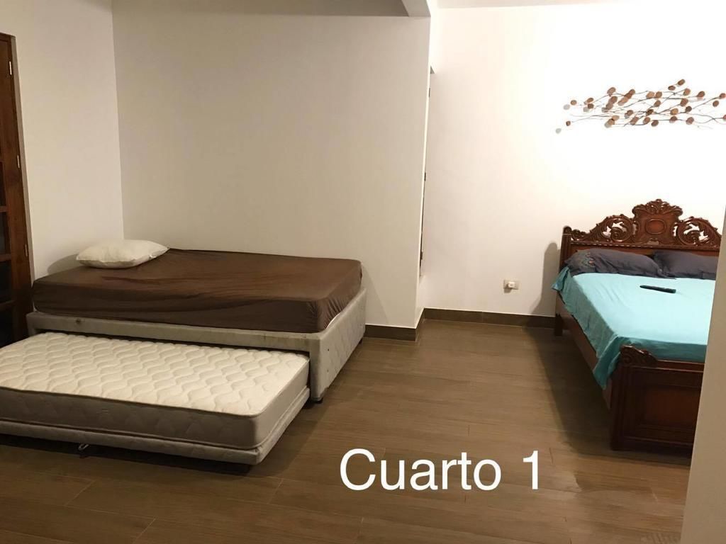 A bedroom with a bed, a mattress, a wooden headboard, and a wall decoration.