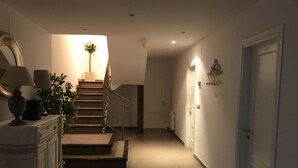 A hallway with a staircase, a radiator, and a door.