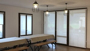 A room with a wooden table, benches, and two pendant lights.