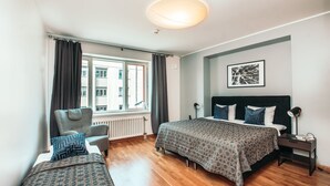 Quarto moderno com cama grande, uma cadeira e uma escrivaninha.