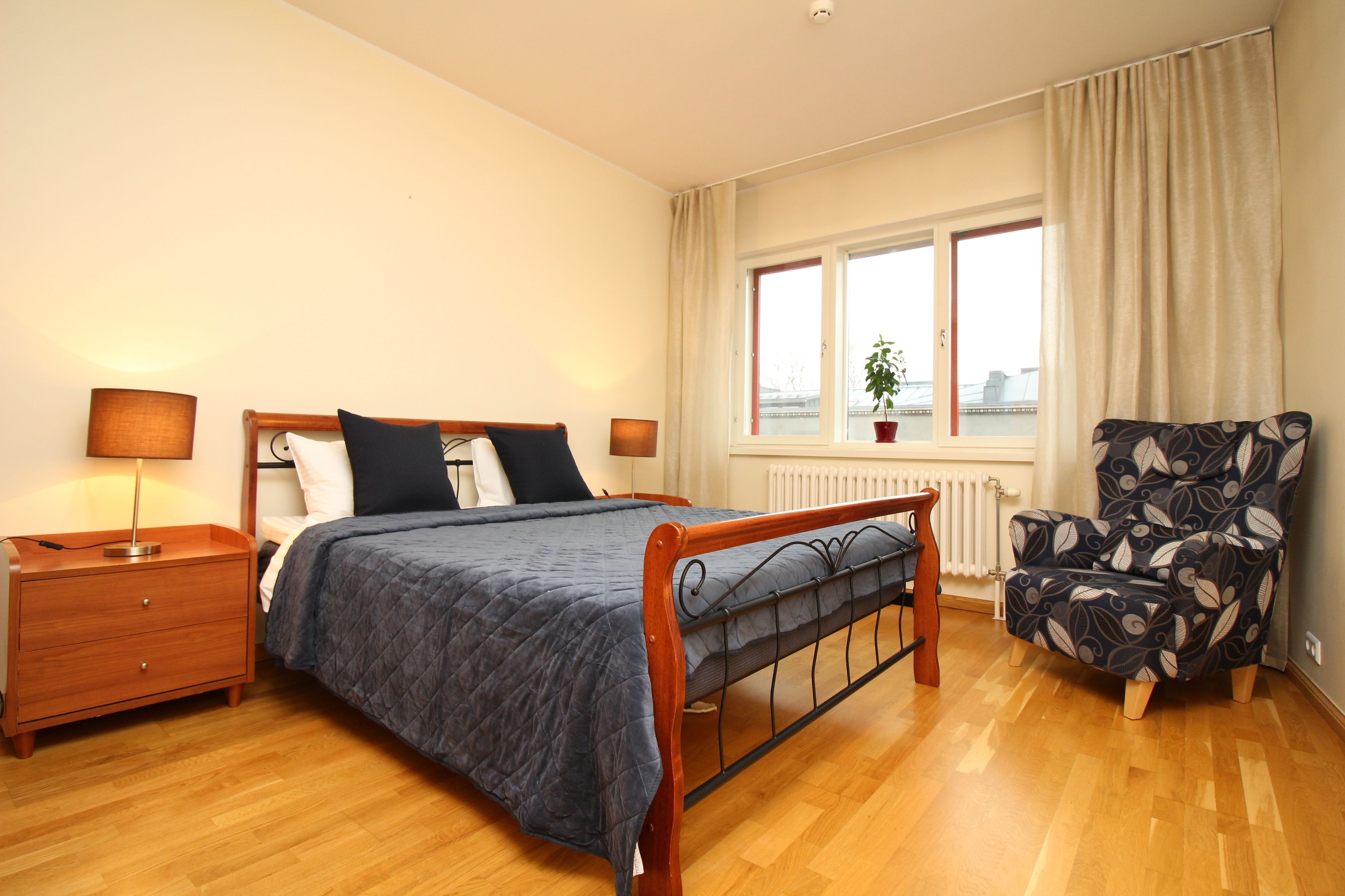 Une chambre à coucher avec un lit en bois, une table de chevet, une chaise et une fenêtre donnant sur un beau paysage.