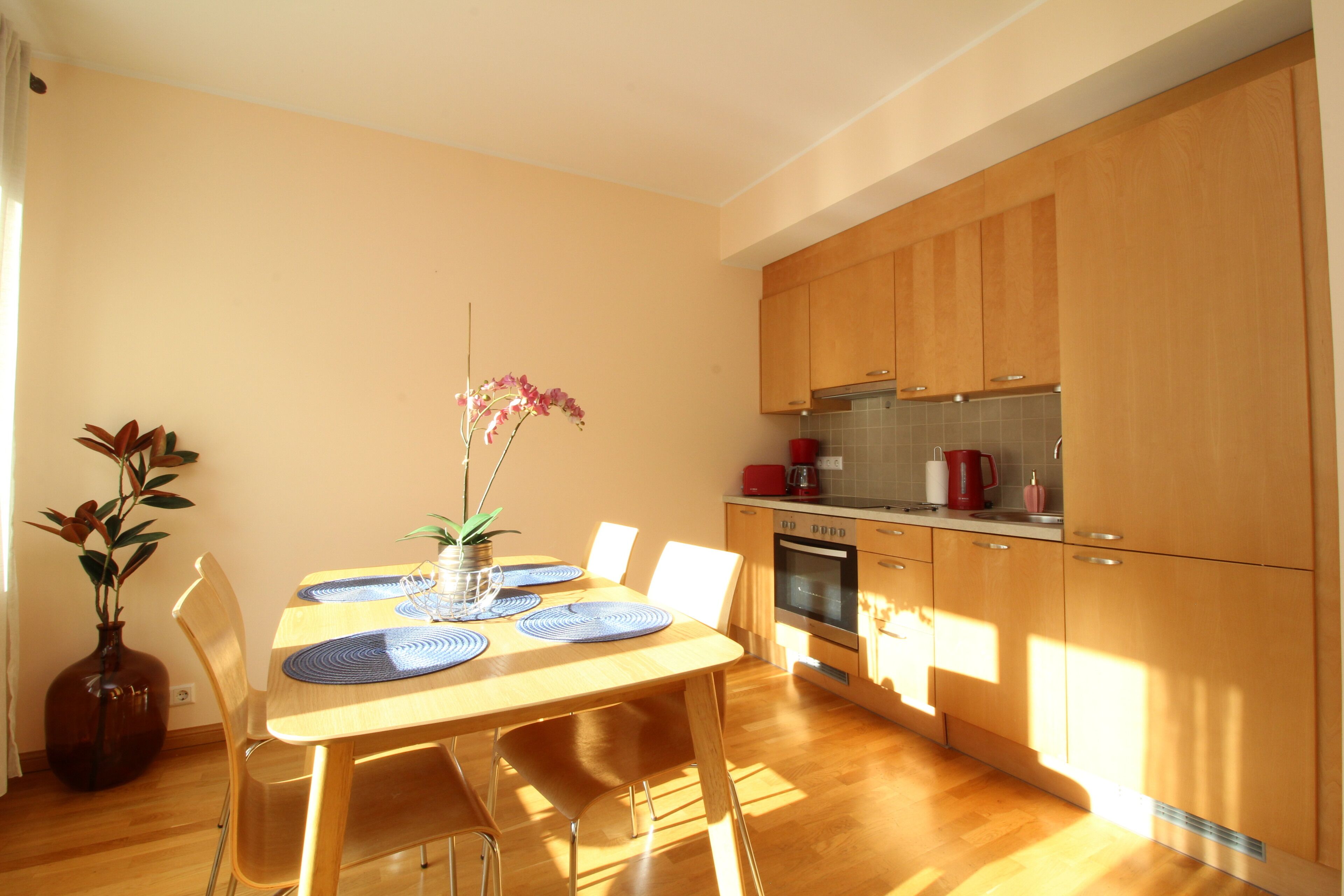 Una cucina moderna con mobili in legno e un'area pranzo con tavolo e sedie in legno.