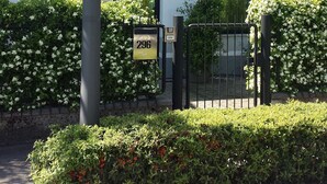 A building with the number 296 on its facade, a gated entrance, and a clear sky. - Guest house 296 (Verona)