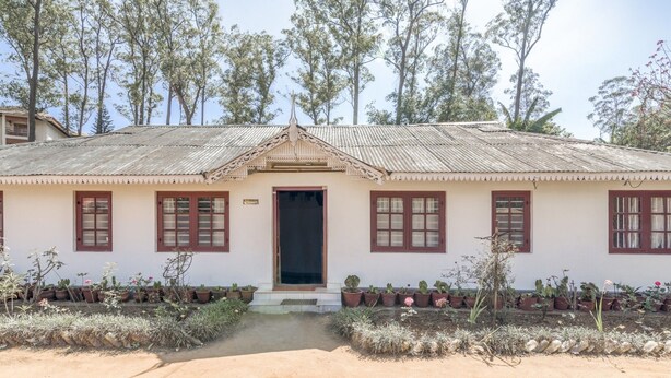 A single-story building with a tiled roof, a central entrance, and a row of windows on the facade. - GuestHouser 4 BHK Homestay f531 (Devikolam)