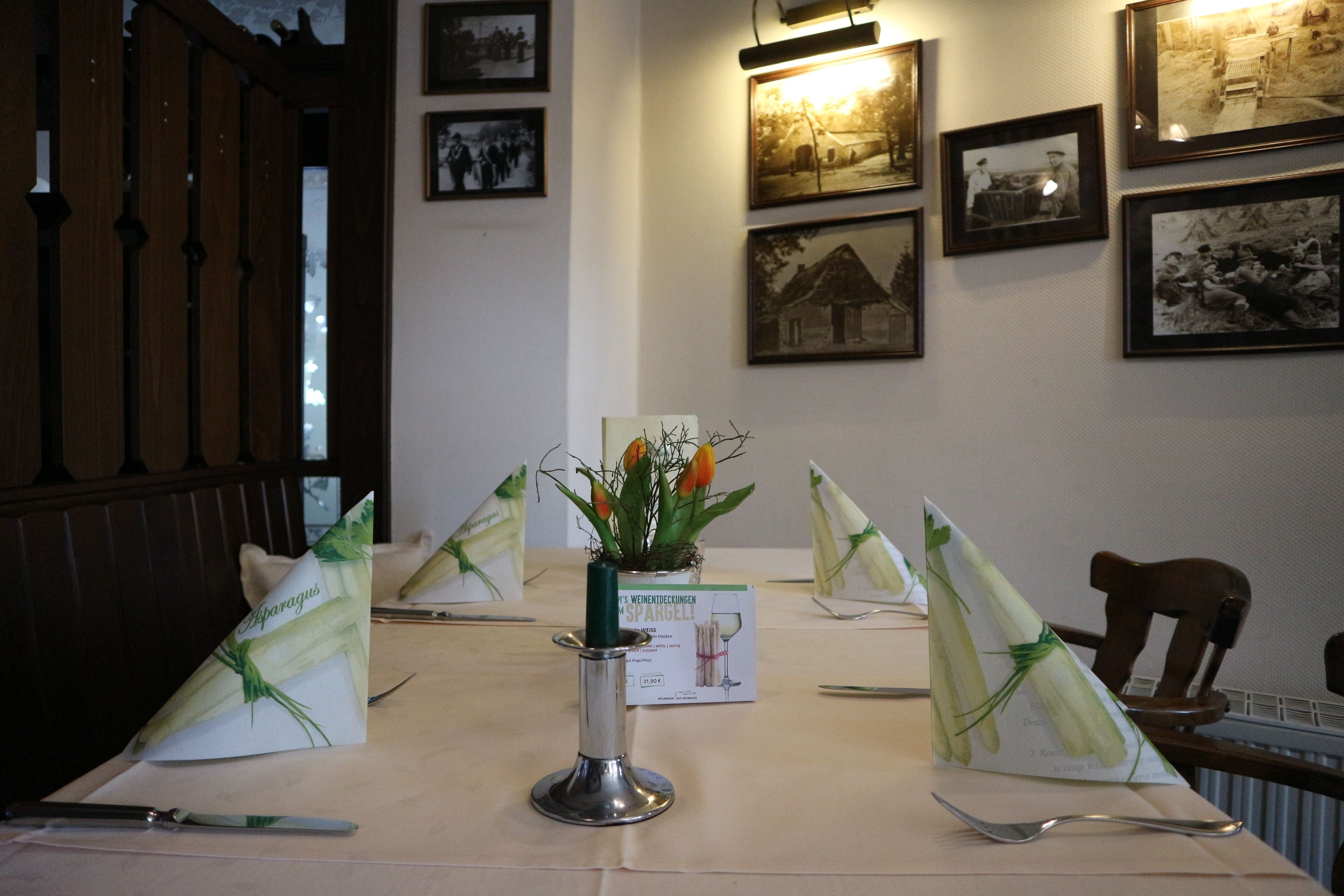Une table à manger agrémentée d’un chandelier, d’un menu et d’une décoration de table comprenant un couteau, une cuillère et une serviette.