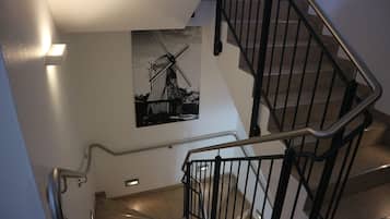 Una escalera con barandilla de metal y un cuadro en blanco y negro de un molino.