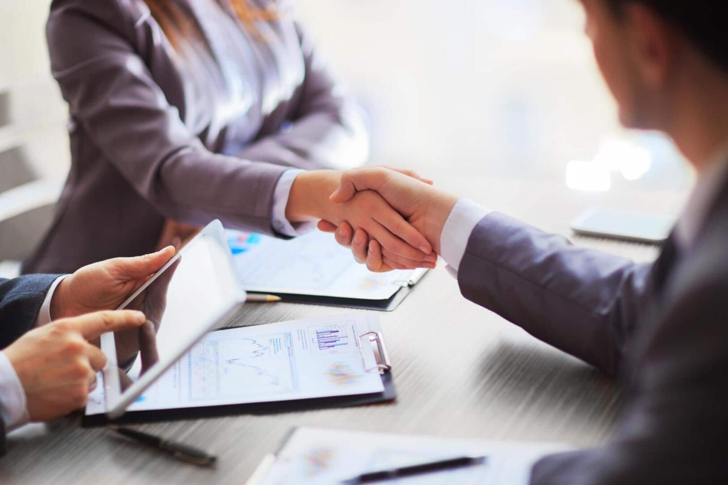 A business meeting with documents and a tablet on a table.