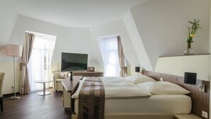 A hotel room with a bed, a desk, a chair, a TV, and a small table. - Gasthof Robben (Twist)