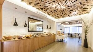 A modern kitchen with wooden cabinets, a long countertop, and pendant lights. - Grand Hotel Gortani Wellness & Relax (Arta Terme)