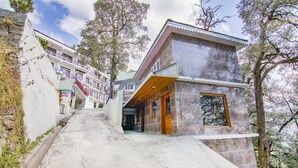 Ein modernes Gebäude mit einer Steinfassade, einem Holzeingang und einer Treppe.