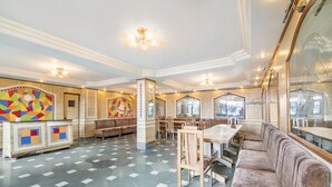 Eine geräumige Lobby mit Schachbrettmuster-Boden, einer Rezeption und Sitzbereichen.