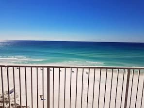 A beach view with a railing in the foreground. - Beach House Condos by Crystal Waters (Destin)