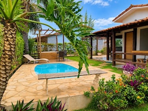 A pool area with a stone patio, lounge chairs, and a pergola. - Charme e Aconchego - Casa para 10 pessoas com 3 quartos (Capitólio)