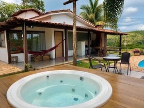Una casa con patio, jacuzzi y vistas a las colinas.