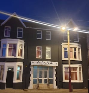 A hotel with a dark facade, white trim, and a signboard with contact information. - Chilton Hotel (Blackpool)