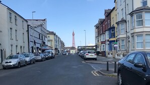 Una calle con coches aparcados y edificios a ambos lados.