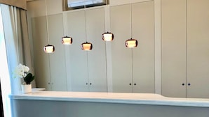 Un comptoir d’accueil au design moderne, doté d’une surface plane et d’un emblème décoratif placé en dessous.