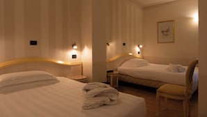 Une chambre d’hôtel avec deux lits, une chaise et une petite table.