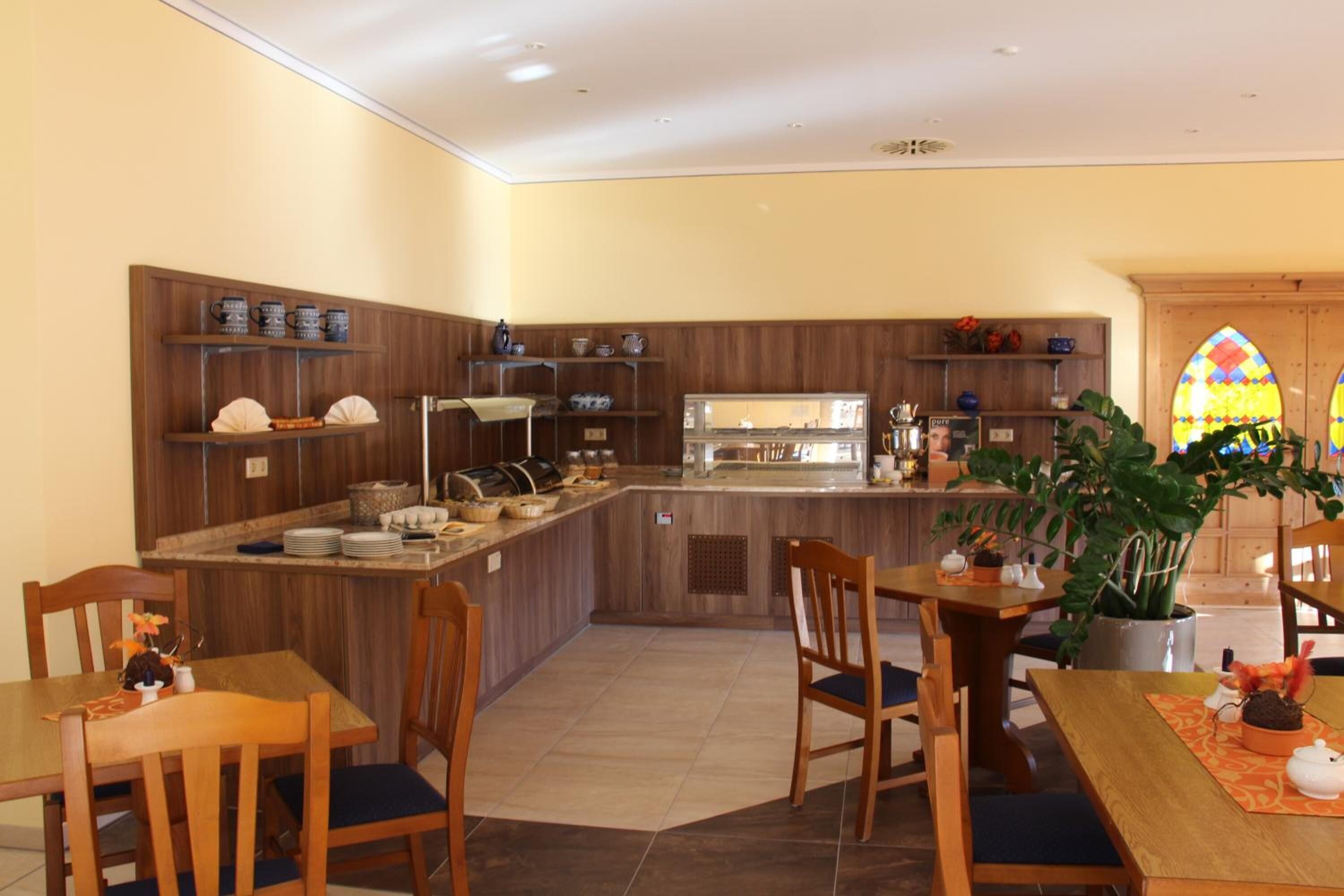 Une cuisine dotée de meubles en bois, d’un îlot central et d’un coin repas avec des chaises et une table.
