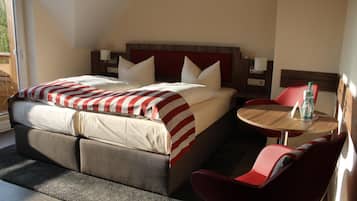Een hotelkamer met een bed, een klein rond tafeltje en een stoel.