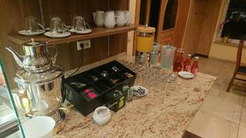 Eine Küche mit Kaffeemaschine, Tee-Zubehör und verschiedenen Flaschen.