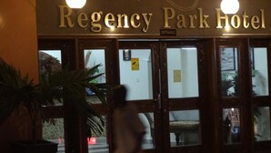 Exterior del hotel Regency Park, con un cartel que indica la entrada.