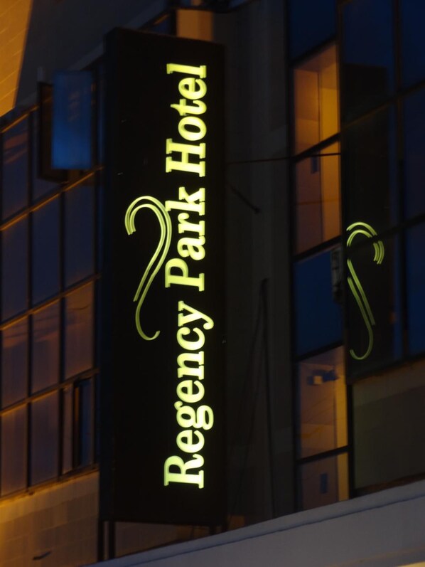 A building with a sign that reads "Regency Park Hotel".