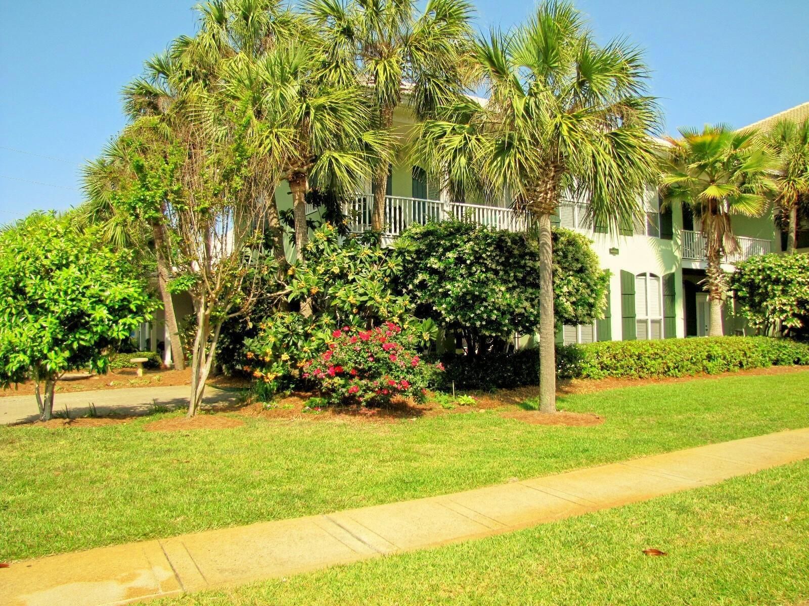 A well-maintained lawn with a pathway leading to a building with a balcony.